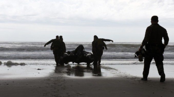Marines with Hotel Company, 2nd Raider Battalion, Marine Corps Forces Special Operations Command (MARSOC) in Camp Lejeune, North Carolina, carry a Zodiac Rigid Hull Inflatable Boat into the surf at Onslow Beach on base, March 28, 2017. (Photo by Petty Officer 3rd Class Corinne Zilnicki, U.S Coast Guard).