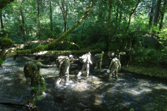 Members of 1st Special Forces Group conduct a stream crossing during the 60th Anniversary "Living History Training Event" held June 2017 (Photo MAJ Alexandra Weiskopf, 1st SFGA)