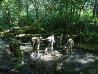 Members of 1st Special Forces Group conduct a stream crossing during the 60th Anniversary "Living History Training Event" held June 2017 (Photo MAJ Alexandra Weiskopf, 1st SFGA)